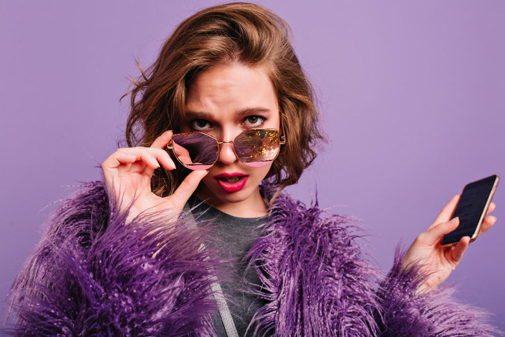 curly hair woman with fashionable glasses an a phone